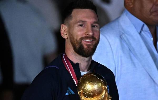 Argentina's captain and forward Lionel Messi (C) holds the FIFA World Cup Trophy upon arrival at Ezeiza International Airport after winning the Qatar 2022 World Cup tournament in Ezeiza, Buenos Aires province, Argentina on December 20, 2022. Luis ROBAYO / AFP