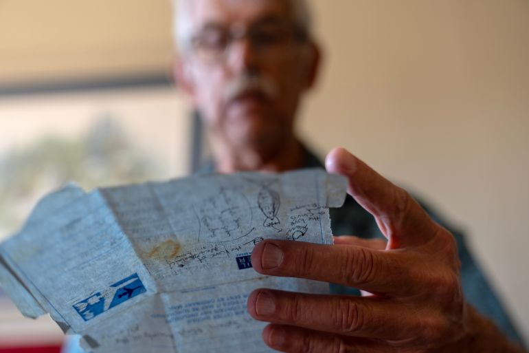 Christy Morrill looks over old letters from his time in college, which still can't help him recall pivotal moments in his own life after losing decades of memories to autoimmune encephalitis, Wednesday, Aug. 20, 2025, at his home in San Carlos, Calif. (AP Photo/David Goldman)